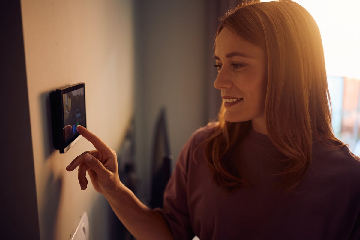Happy woman smart security system at home.
