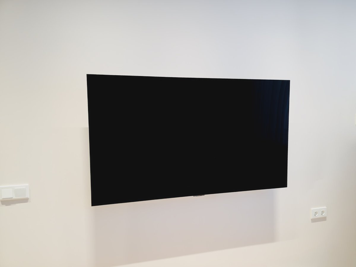 Minimalist interior with flat television fixed to bright clean white wall